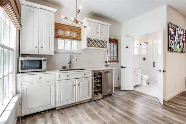 kitchen featuring white cabinetry, sink, and light hardwood / wood-style flooring