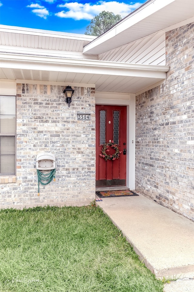 doorway to property featuring a lawn