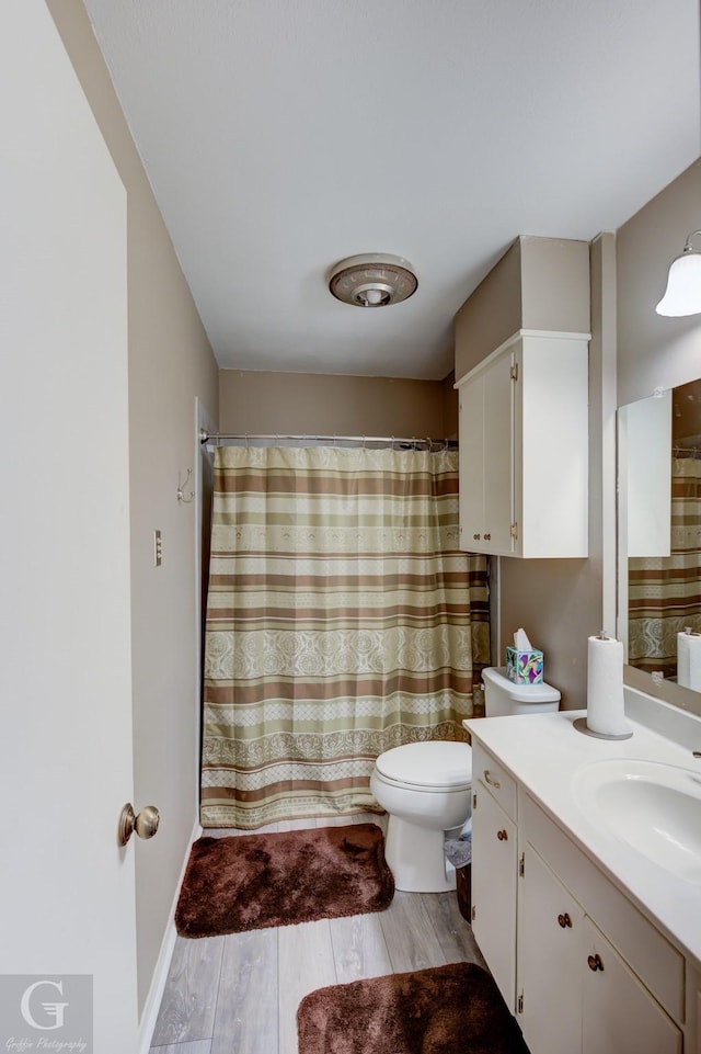 bathroom featuring vanity, hardwood / wood-style floors, and toilet