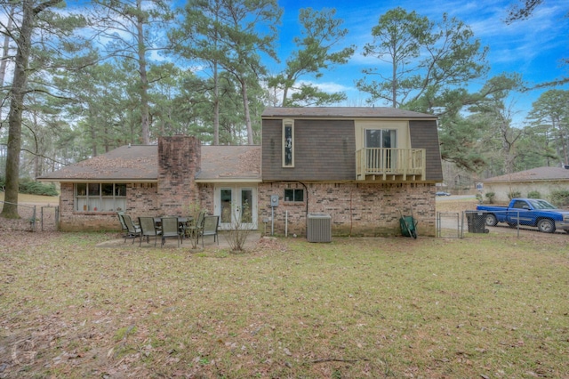 rear view of house with central AC, a lawn, french doors, and a patio area