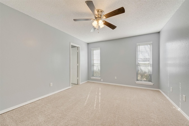 unfurnished room with plenty of natural light, light carpet, a textured ceiling, and ceiling fan