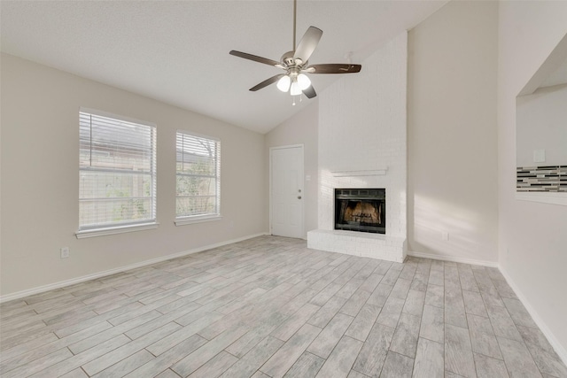 unfurnished living room featuring ceiling fan, high vaulted ceiling, a brick fireplace, and light hardwood / wood-style flooring