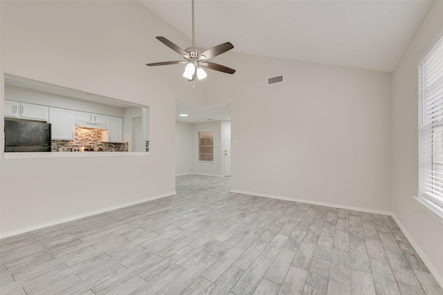 unfurnished living room featuring light hardwood / wood-style flooring, plenty of natural light, high vaulted ceiling, and ceiling fan