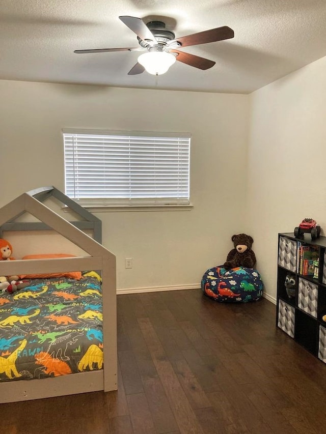 bedroom featuring ceiling fan, dark wood-type flooring, and a textured ceiling