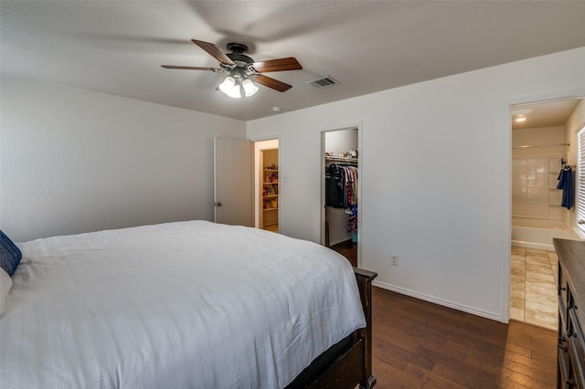 bedroom with ceiling fan, connected bathroom, dark hardwood / wood-style flooring, a spacious closet, and a closet