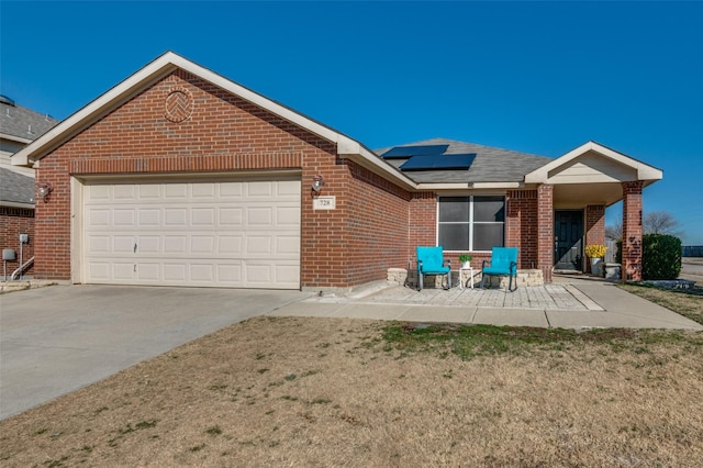 view of front of house with a garage, a front lawn, and solar panels