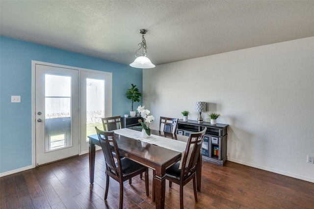 dining space with dark hardwood / wood-style flooring and a textured ceiling