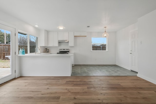 kitchen with white cabinetry, wood-type flooring, stainless steel range with electric stovetop, hanging light fixtures, and kitchen peninsula