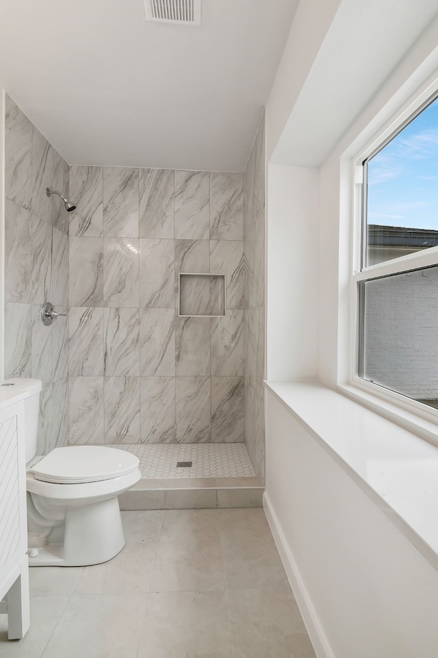 bathroom featuring toilet and tiled shower