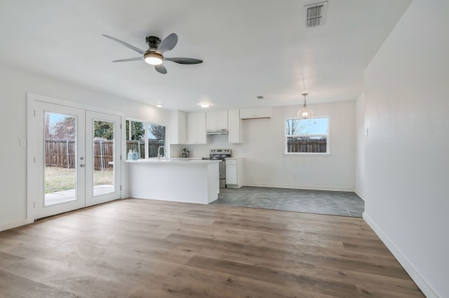 kitchen with french doors, stainless steel range with electric cooktop, white cabinetry, kitchen peninsula, and light hardwood / wood-style floors