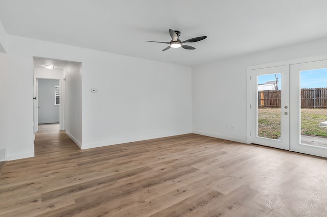 spare room featuring french doors, ceiling fan, and light wood-type flooring