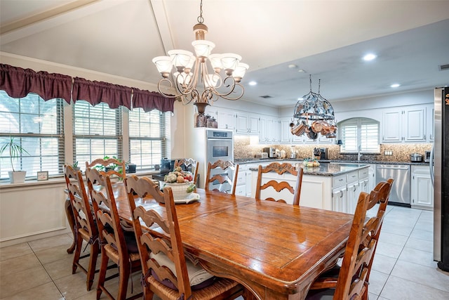 dining area with sink, vaulted ceiling, a chandelier, and light tile patterned flooring