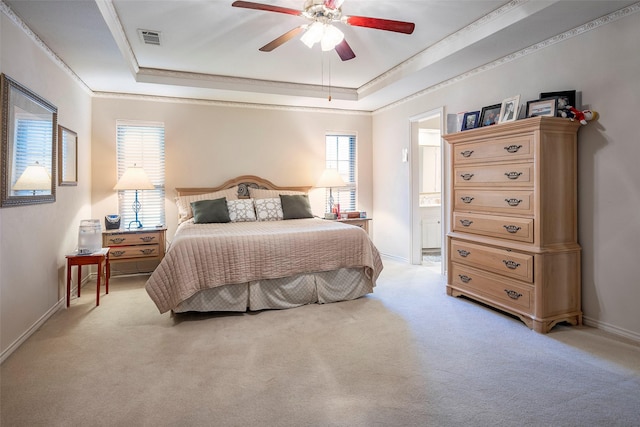 bedroom with a tray ceiling, ornamental molding, light colored carpet, and ceiling fan