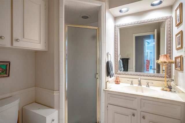 bathroom with toilet, vanity, and walk in shower