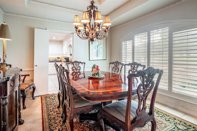 dining space featuring light tile patterned floors, ornamental molding, a raised ceiling, and a chandelier