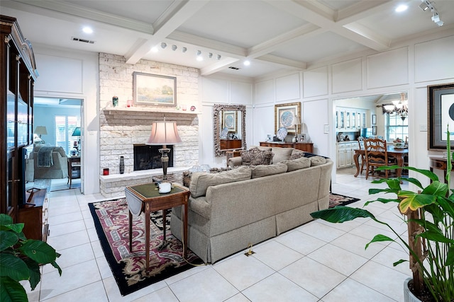 living room with light tile patterned flooring, a fireplace, a chandelier, coffered ceiling, and beam ceiling