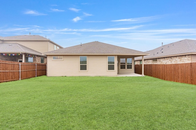 rear view of house with a yard and a patio area