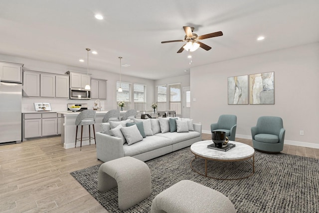 living room featuring light hardwood / wood-style floors and ceiling fan