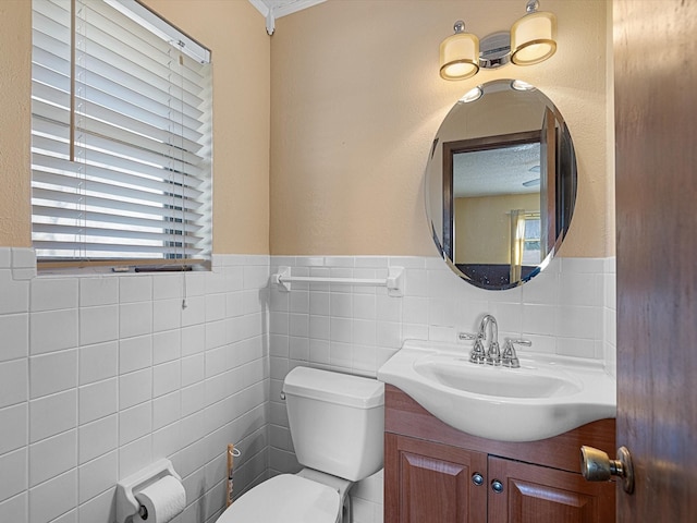 bathroom featuring vanity, tile walls, and toilet