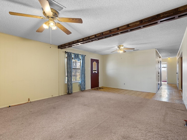 carpeted spare room featuring ceiling fan and a textured ceiling