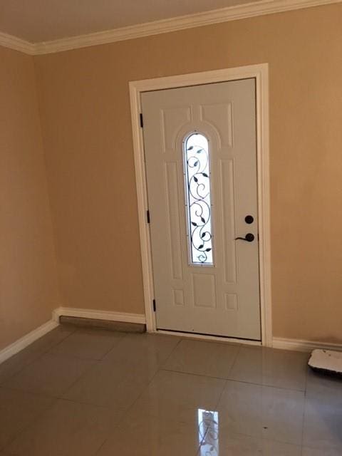 foyer with tile patterned flooring and crown molding