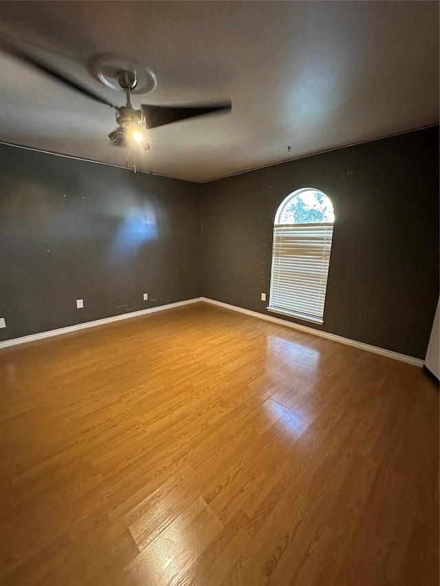 empty room with hardwood / wood-style floors and ceiling fan