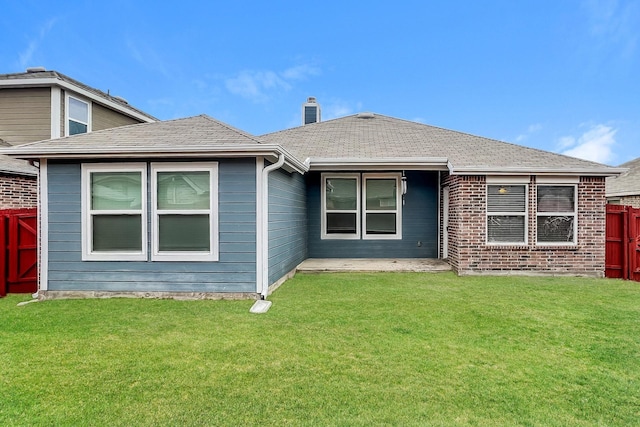 rear view of house featuring a lawn