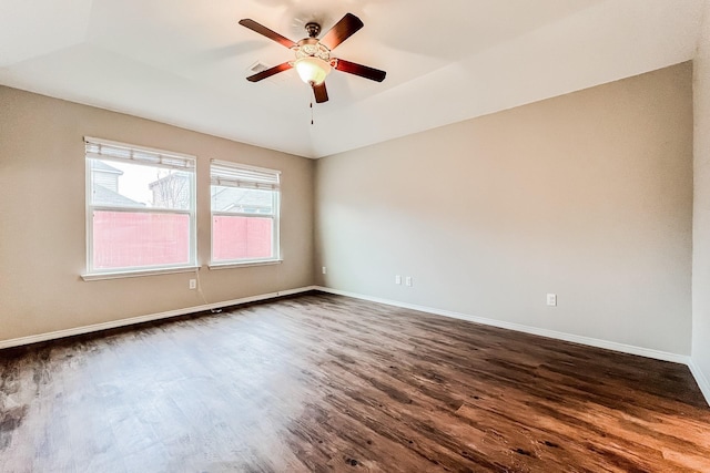 unfurnished room featuring ceiling fan, dark hardwood / wood-style floors, and vaulted ceiling