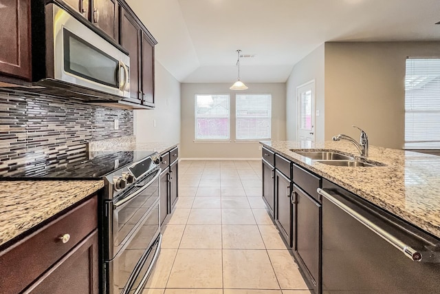 kitchen featuring light tile patterned flooring, appliances with stainless steel finishes, sink, backsplash, and hanging light fixtures