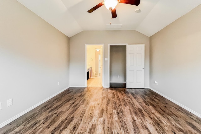 unfurnished bedroom with ceiling fan, lofted ceiling, dark hardwood / wood-style flooring, and connected bathroom