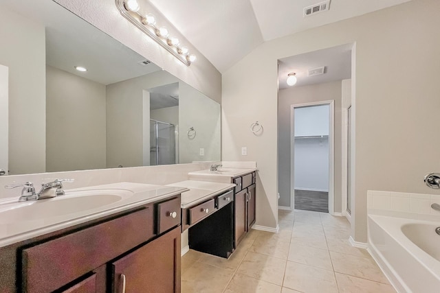 bathroom with tile patterned flooring, vanity, vaulted ceiling, and separate shower and tub