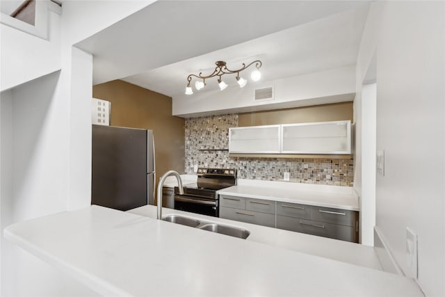 kitchen with sink, tasteful backsplash, gray cabinets, kitchen peninsula, and stainless steel appliances