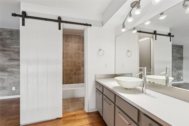 bathroom featuring vanity, tiled shower / bath combo, and hardwood / wood-style floors