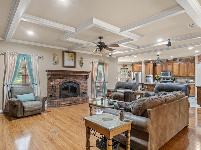 living room with beamed ceiling, coffered ceiling, a brick fireplace, and light wood-type flooring