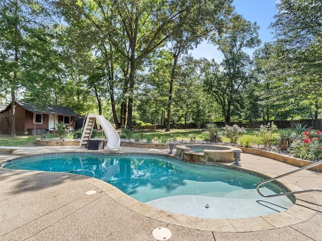 view of swimming pool with an outdoor structure, an in ground hot tub, and a water slide