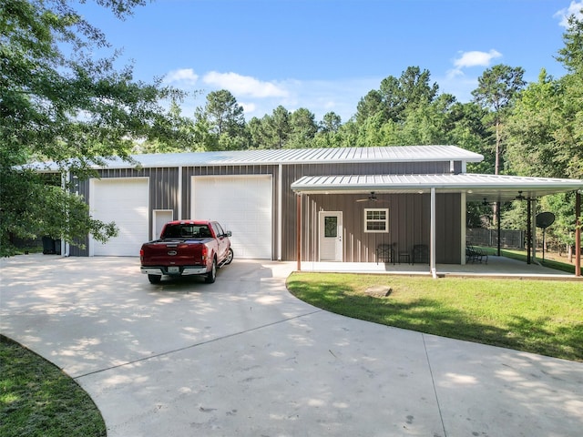 view of front of home featuring a garage, an outdoor structure, a front yard, and ceiling fan