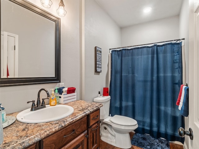 full bathroom with vanity, shower / tub combo with curtain, and toilet