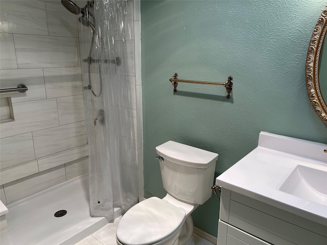 full bath with a shower stall, a textured wall, vanity, and toilet