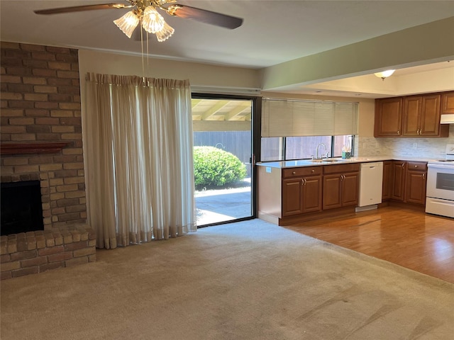 2118 Courtland Cir, Carrollton, TX 75007 - kitchen with white appliances, light colored carpet, a ceiling fan, a sink, and under cabinet range hood