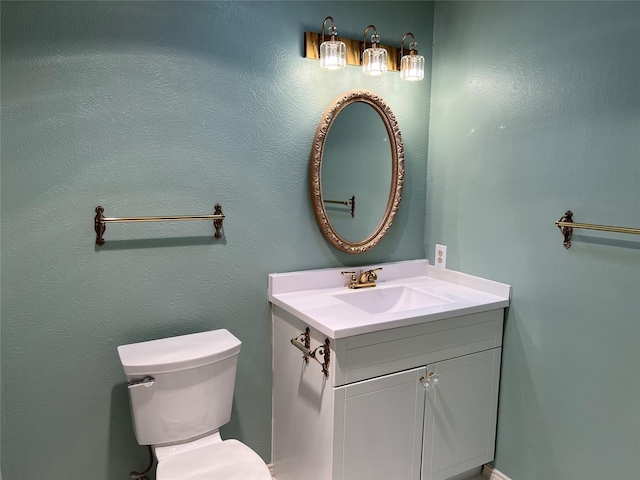 half bathroom with vanity and toilet