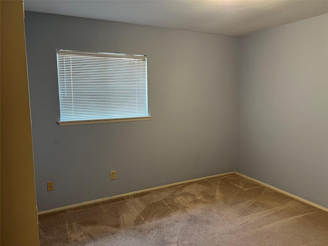 empty room with carpet and baseboards