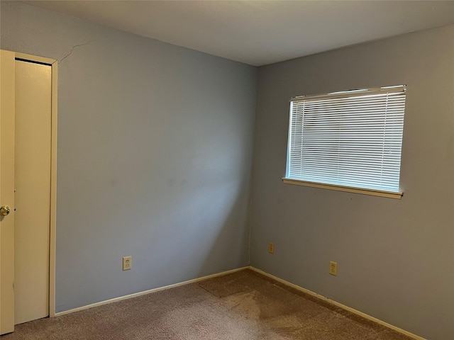 carpeted empty room with baseboards