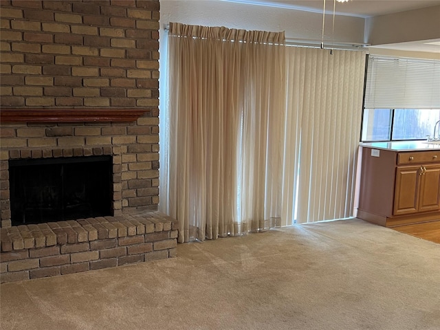 unfurnished living room with light colored carpet and a fireplace