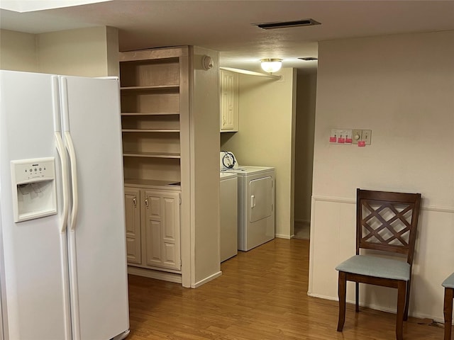 washroom featuring visible vents, separate washer and dryer, wood finished floors, and wainscoting