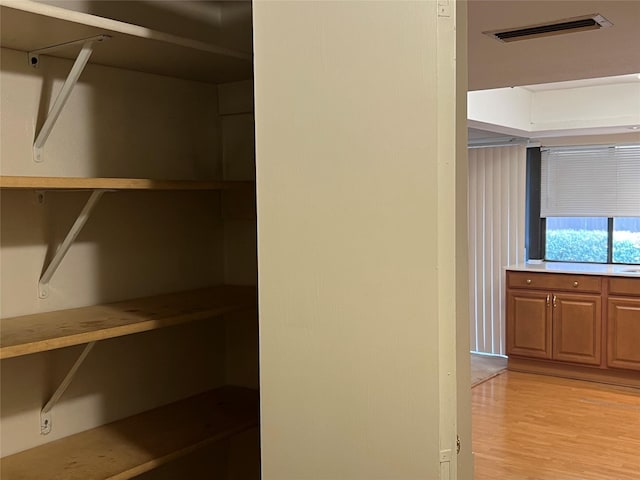 walk in closet with light wood-type flooring and visible vents