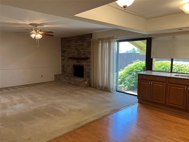 2118 Courtland Cir, Carrollton, TX 75007 - unfurnished living room with plenty of natural light, a ceiling fan, a fireplace, and light wood finished floors