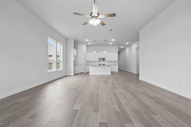 1804 Night Owl Way, Mesquite, TX 75181 - unfurnished living room featuring light wood-type flooring, baseboards, a ceiling fan, and recessed lighting