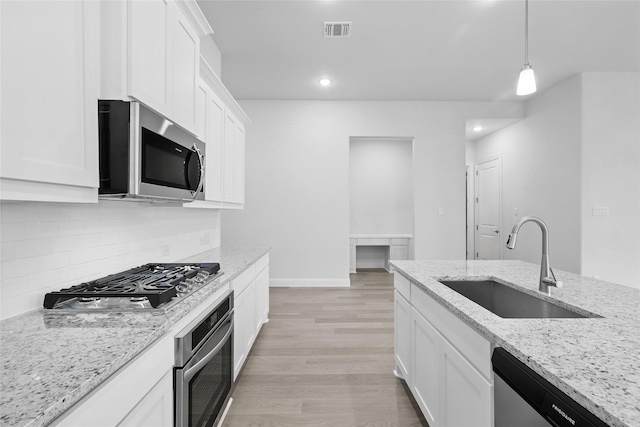 1804 Night Owl Way, Mesquite, TX 75181 - kitchen featuring a sink, light wood finished floors, backsplash, white cabinets, and appliances with stainless steel finishes