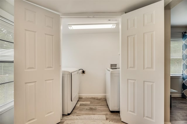 clothes washing area featuring washing machine and dryer and light hardwood / wood-style flooring