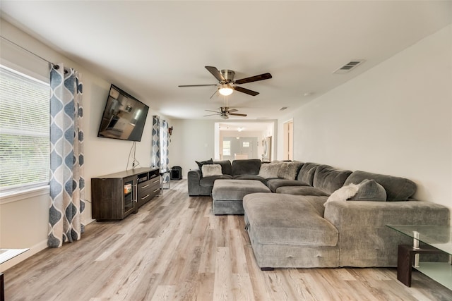 living room with ceiling fan and light wood-type flooring